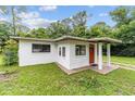 Charming single-story home featuring a red door, stucco siding, and a well-maintained front lawn at 2602 Ne 2Nd Ave, Ocala, FL 34470