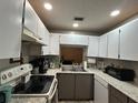 Efficient kitchen with updated countertops, white cabinets, and a stainless steel sink at 3525 E Fort King St # 140, Ocala, FL 34470