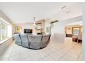 Open living room featuring tile floors, a stone fireplace, and comfortable seating at 3831 Se 48Th St, Ocala, FL 34480