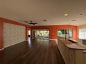 Spacious living room featuring wood flooring, ceiling fan, and large sliding glass doors for plenty of natural light at 3950 Sw 54Th Ct, Ocala, FL 34474