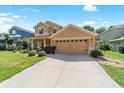 Inviting two-story home featuring manicured lawn, tidy shrubbery, and neutral stucco exterior with an attached two car garage at 4094 Sw 51St Ct, Ocala, FL 34474
