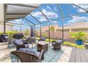 Inviting screened patio featuring comfortable wicker seating, a cozy fire pit, and lush landscaping at 4340 Nw 56Th Ct, Ocala, FL 34482