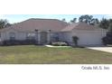 Wide shot of a single story home with tidy lawn, landscaping and attached garage at 4420 Sw 100Th St, Ocala, FL 34476