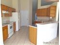 Functional kitchen featuring tile floors, plentiful cabinetry, and counter seating area at 4420 Sw 100Th St, Ocala, FL 34476