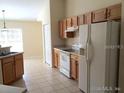 Bright kitchen with tile flooring, ample cabinet space, and appliances including a white refrigerator and range at 4420 Sw 100Th St, Ocala, FL 34476