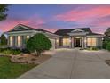 Charming single-story home with a well-kept lawn and an extra-long concrete driveway at dusk at 5093 Nw 35Th Lane Rd, Ocala, FL 34482