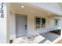 Close-up of the home's entrance with a gray front door, sidelight window, and covered porch at 5388 Nw 9Th St, Ocala, FL 34482