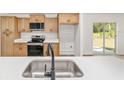 Modern kitchen features stainless steel appliances, quartz countertops, and a view to the outdoors at 5400 Nw 9Th St, Ocala, FL 34482