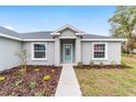 Attractive home facade with light blue front door, complemented by new landscaping at 5908 Sw 111Th Place Rd, Ocala, FL 34476