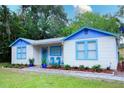 Inviting home with colorful trim, landscaped front yard, and a cozy seating area on the porch at 626 Ne 21St St, Ocala, FL 34470