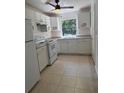 A functional kitchen featuring white cabinets and tile flooring at 6415 Ne 23Rd Ave, Ocala, FL 34479