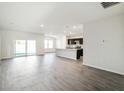 Spacious open-concept living room seamlessly connects to the modern kitchen and features sliding glass doors to the backyard at 6865 Sw 153 Place Rd, Ocala, FL 34473