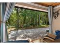 Relaxing screened patio view, with brick floors and a glimpse of the lush, green backyard at 7242 Sw 115Th Pl, Ocala, FL 34476
