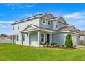Side view of a two-story home featuring well-maintained landscaping and a welcoming front porch at 7695 Sw 64Th Street Rd, Ocala, FL 34474
