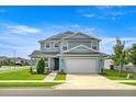 Inviting two-story home with a manicured lawn, two-car garage, and classic curb appeal at 7695 Sw 64Th Street Rd, Ocala, FL 34474