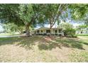 Well-maintained home featuring mature trees, landscaping, sidewalk, and green lawn at 8973 Sw 104Th Pl, Ocala, FL 34481