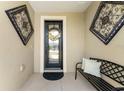 Close-up of a welcoming front door with a wreath, flanked by decorative metal art at 9634 Sw 67Th St, Ocala, FL 34481