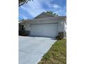 Two-car garage with white door and concrete driveway of a single story home at 9711 Sw 97Th Pl, Ocala, FL 34481