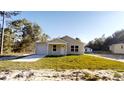 Inviting single-story home with an attached garage, nestled amidst lush greenery and mature trees at 2740 Sw 147Th Ter, Ocala, FL 34481