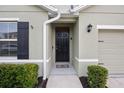 Inviting front entrance with a sleek black door, dark shutters, and tidy landscaping at 2984 Ne 43Rd Rd, Ocala, FL 34470