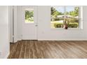 Bright living room with hardwood floors, exit door, and a large window at 3640 Se 131St Ln, Belleview, FL 34420