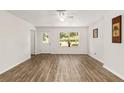 Bright living room with hardwood floors, exit door, and a large window at 3640 Se 131St Ln, Belleview, FL 34420