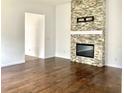 Open-concept living room with hardwood floors and decorative stone fireplace at 3983 Sw 51St Ct, Ocala, FL 34474