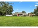 Well-kept single story home with a lush lawn and landscape; complemented by a red front door at 4360 Se 106Th St, Belleview, FL 34420