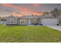 Charming single-story home with a well-maintained lawn, pretty landscaping, and modern design at 4661 Sw Gardenia Ct, Dunnellon, FL 34431