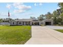 Charming single-story home boasts a manicured lawn, large driveway and detached two-car garage at 4661 Sw Gardenia Ct, Dunnellon, FL 34431