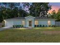 Charming single-story home with a well-manicured lawn and fresh landscaping at dusk at 5740 Nw 61St St, Ocala, FL 34482
