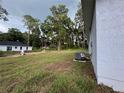 Large backyard view highlighting green space with trees, along with home's AC unit at 6422 Nw 62Nd Pl, Ocala, FL 34482