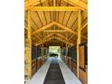 Spacious interior of a modern barn with wooden stalls and high ceilings at 7041 Ne 22Nd Court Rd, Ocala, FL 34479