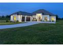 A well-lit home with an attached garage, lush lawn, and beautiful landscaping at 7041 Ne 22Nd Court Rd, Ocala, FL 34479