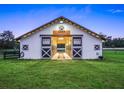 Exterior of horse barn featuring a sign and rustic accents, set against a backdrop of expansive greenery at 7041 Ne 22Nd Court Rd, Ocala, FL 34479