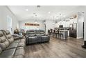 Open-concept living room with modern furnishings, hardwood floors, and seamless flow to the kitchen at 710 Barwick St, Wildwood, FL 34785
