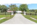Long driveway leading to a charming home with a gated entrance and a beautifully landscaped yard at 7220 Nw 83 Ter, Ocala, FL 34482