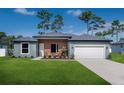 Charming single-story home with well-manicured lawn, cozy front porch and attached two-car garage at 7364 Sw 133 Ne Loop, Ocala, FL 34473