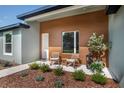 Inviting front porch with seating area, complemented by lush landscaping and modern exterior design at 7364 Sw 133 Ne Loop, Ocala, FL 34473