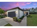 Charming single-story home featuring a well-manicured lawn, gray garage door, and inviting front entrance at 7707 Sw 94Th Cir, Ocala, FL 34481
