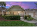 Charming single-story home with a covered front porch, stone accents, and well-maintained landscaping at dusk at 9065 Sw 82Nd Ter # G, Ocala, FL 34481