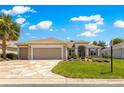 Beautiful home features a three-car garage, custom driveway, and manicured lawn with charming landscaping at 9415 Se 125Th St, Summerfield, FL 34491