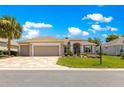 Inviting home with a three-car garage, stone driveway, manicured lawn, and enhanced landscaping at 9415 Se 125Th St, Summerfield, FL 34491