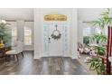 Elegant foyer with decorative door, sleek flooring, and natural light streaming through surrounding windows at 9562 Sw 45Th Ave, Ocala, FL 34476