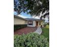 Inviting single-story home with a cozy front porch, brick pathway, and lush landscaping at 9706 Sw 92Nd Place Rd, Ocala, FL 34481