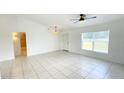 Bright living room with neutral walls, ceiling fan, and large window at 10758 Se Highway 464C, Ocklawaha, FL 32179