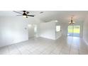 Bright living room with neutral walls, ceiling fan, chandelier and sliding glass doors at 10758 Se Highway 464C, Ocklawaha, FL 32179