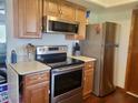 Well-maintained kitchen with stainless steel appliances, wooden cabinets, and laminate countertops at 10945 Sw 75Th Ave, Ocala, FL 34476