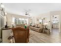Inviting living room featuring comfortable leather seating, ceiling fan, and stylish decor at 12489 Se 90Th Ter, Summerfield, FL 34491