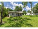 Well-kept home with a metal roof, covered front porch, and spacious yard with mature trees at 1330 Ne 55Th St, Ocala, FL 34479